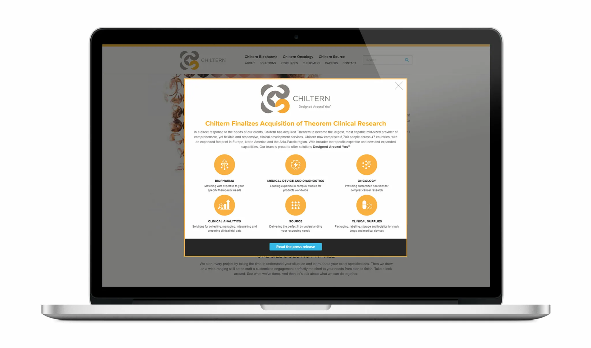 Laptop screen displaying a website overlay from Chiltern announcing its acquisition of Theorem Clinical Research. The message highlights expanded global capabilities across 47 countries and emphasizes Chiltern's commitment to flexible and responsive clinical development services. Icons and brief descriptions are shown for six service areas: Biopharma, Medical Device and Diagnostics, Oncology, Clinical Analytics, Source, and Clinical Supplies. A button labeled 'Read the press release' appears at the bottom.