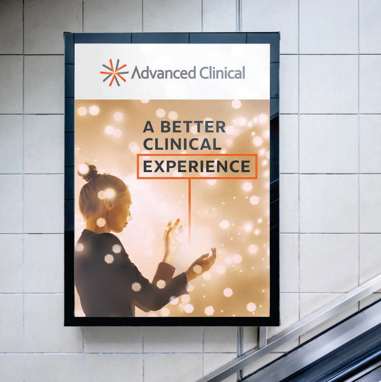 A professional advertisement for Advanced Clinical, displayed on a tiled wall near an escalator. The ad features a woman in profile, reaching out toward glowing lights, with the slogan "A Better Clinical Experience" prominently displayed. The design incorporates warm golden tones and a modern aesthetic.