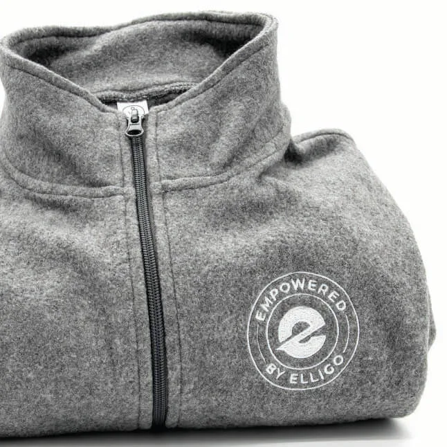 A folded gray fleece zip-up jacket with a high collar, featuring the Elligo Health Research logo embroidered in white on the left chest area. The logo includes the words 'EMPOWERED BY ELLIGO' encircling the stylized 'e' emblem. The jacket is neatly displayed against a white background.