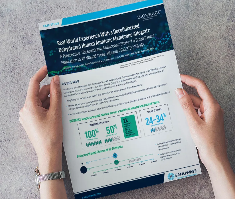A person holding a printed case study titled 'Real-World Experience With a Decellularized Dehydrated Human Amniotic Membrane Allograft' for Sanuwave's BIOVANCE product. The document highlights the positive results of BIOVANCE in wound closure for various wound types, with key statistics showing 100% closure at 8 weeks, 50% faster healing compared to standard care, and projected wound closure at 12-20 weeks. The background features abstract, glowing blue and green dots, emphasizing the regenerative properties of the product.