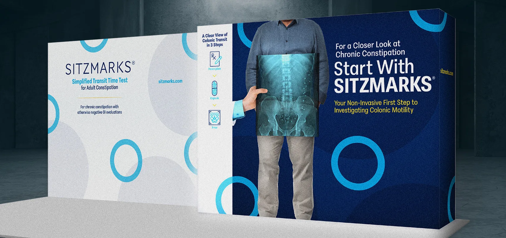 Trade show booth display for SITZMARKS featuring large wall graphics with X ray visual and messaging about simplified transit time testing