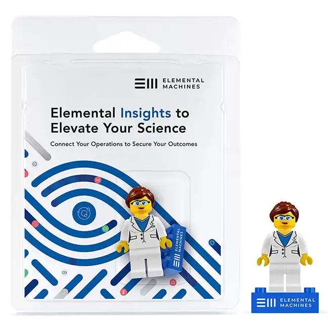 Elemental Machines branded LEGO minifigure dressed as a scientist, shown in retail packaging and standing alone on a logo brick.